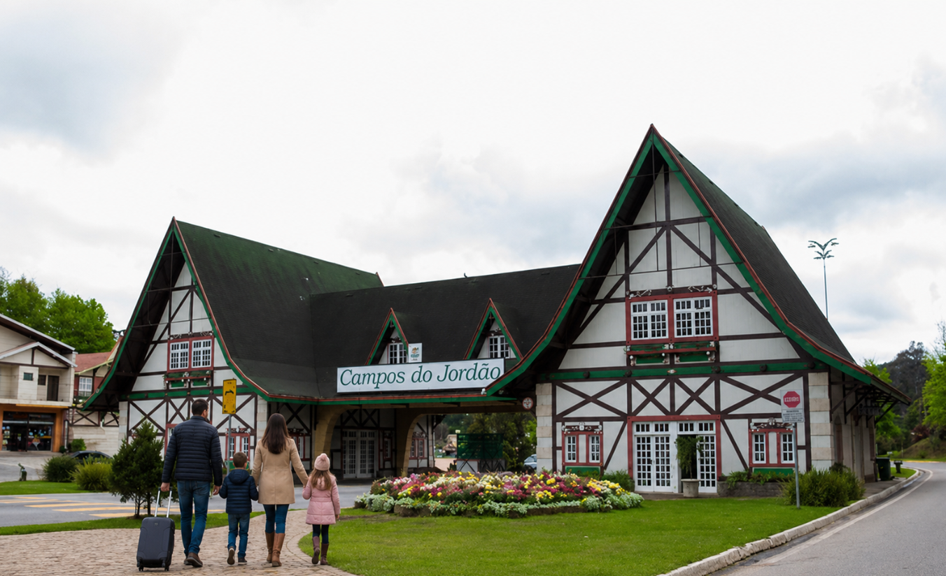 Família chegando ao portal de entrada de Campos do Jordão com arquitetura alpina, montanhas e araucárias ao fundo em dia de frio