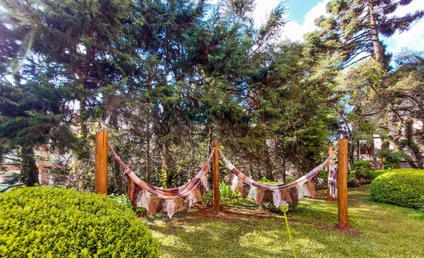 Jardim aconchegante da Pousada Victoria Villa em Campos do Jordão, com paisagismo cuidado e atmosfera romântica
