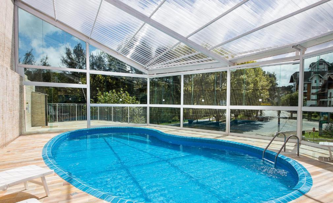 Piscina aquecida do Hotel Euro Suíte em Campos do Jordão com área de lazer e ambiente acolhedor ao redor