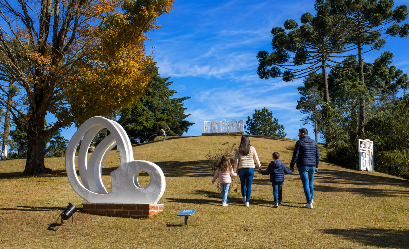 Família caminhando por um jardim de esculturas ao ar livre em Campos do Jordão